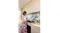 Modern kitchen with black glass rangehood, marble splashback, cooktop, and a person preparing food on the countertop Modern kitchen with black glass rangehood, marble splashback, cooktop, and a person preparing food on the countertop