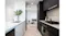 Modern kitchen setup with white and black cabinetry, gas cooktop, integrated black glass rangehood, and open living area Modern kitchen setup with white and black cabinetry, gas cooktop, integrated black glass rangehood, and open living area