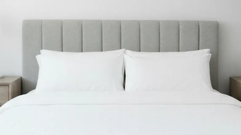 Nile queen upholstered headboard fabric with vertical panels, paired with white pillows in a bedroom setting Nile queen upholstered headboard fabric with vertical panels, paired with white pillows in a bedroom setting