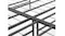 Close-up of a folding joint and wire grid on a black metal bed frame, showing the centre hinge and support bars Close-up of a folding joint and wire grid on a black metal bed frame, showing the centre hinge and support bars