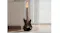 Black electric guitar leaning against a wall beside a cabinet and a curtain in a softly lit indoor room Black electric guitar leaning against a wall beside a cabinet and a curtain in a softly lit indoor room