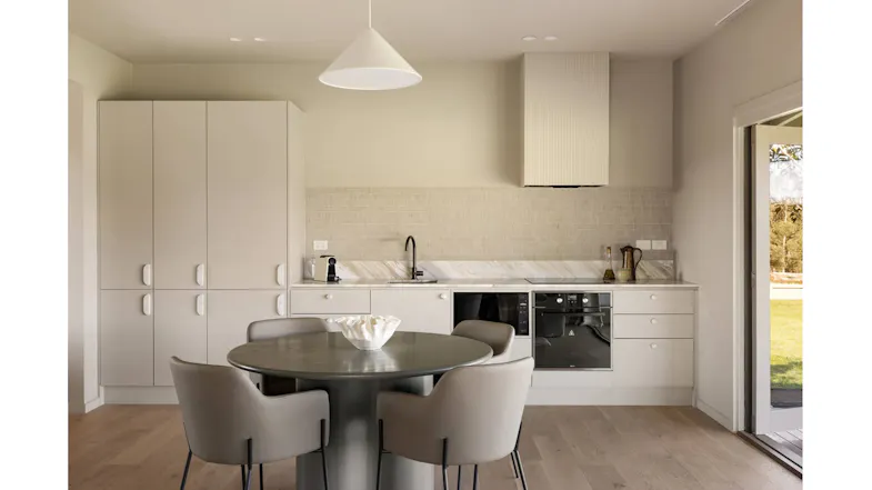 Modern kitchen with a round dining table, four chairs, built-in cabinets, oven, and rangehood Modern kitchen with a round dining table, four chairs, built-in cabinets, oven, and rangehood