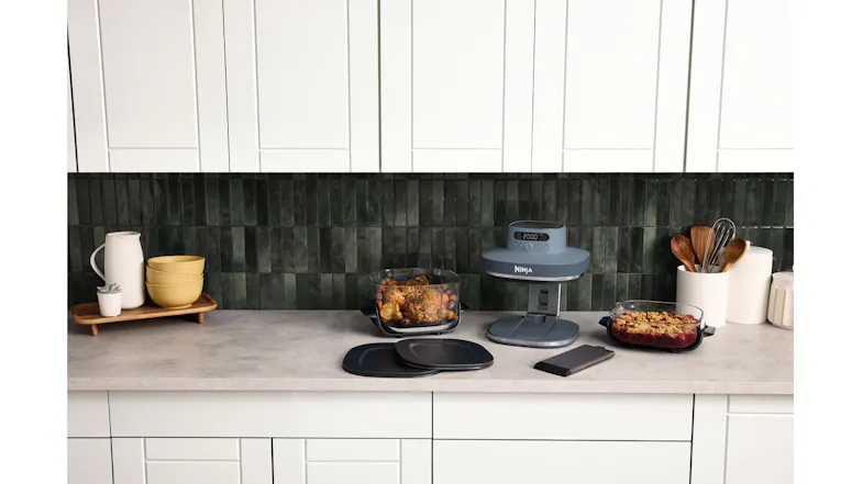 Wide kitchen countertop scene showing the Ninja Crispi Pro air fryer with accessories and glass containers Wide kitchen countertop scene showing the Ninja Crispi Pro air fryer with accessories and glass containers