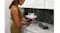 Kitchen countertop scene showing a person inserting a flat tray into the Ninja Crispi Pro base Kitchen countertop scene showing a person inserting a flat tray into the Ninja Crispi Pro base