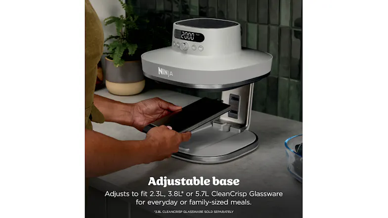 Close-up of Ninja Crispi Pro with a person sliding in an adjustable base tray Close-up of Ninja Crispi Pro with a person sliding in an adjustable base tray
