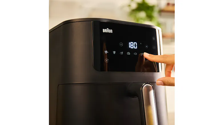 Close-up of the Braun MultiFry 5 digital control panel set to 180°C, with a hand tapping touch icons Close-up of the Braun MultiFry 5 digital control panel set to 180°C, with a hand tapping touch icons