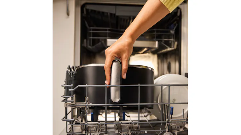 Person placing the Braun MultiFry 5 air fryer basket into a dishwasher rack, holding the silver handle Person placing the Braun MultiFry 5 air fryer basket into a dishwasher rack, holding the silver handle