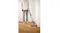 Vacuum in use on a wooden floor, cleaning along the edge of a wall Vacuum in use on a wooden floor, cleaning along the edge of a wall