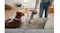 Close-up of the floor head moving from hard floor onto a light rug, picking up scattered crumbs Close-up of the floor head moving from hard floor onto a light rug, picking up scattered crumbs