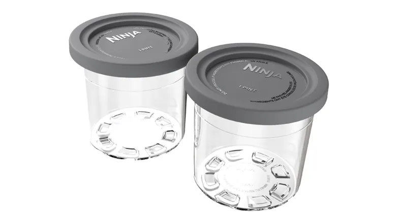 Two clear Ninja Creami 1‑pint containers with grey lids placed side by side, showing empty interiors Two clear Ninja Creami 1‑pint containers with grey lids placed side by side, showing empty interiors