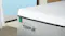 Close-up of a Tempur mattress corner highlighting the fabric cover and brand logo Close-up of a Tempur mattress corner highlighting the fabric cover and brand logo