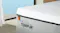 Close-up of a Tempur mattress corner highlighting the fabric cover and brand logo Close-up of a Tempur mattress corner highlighting the fabric cover and brand logo