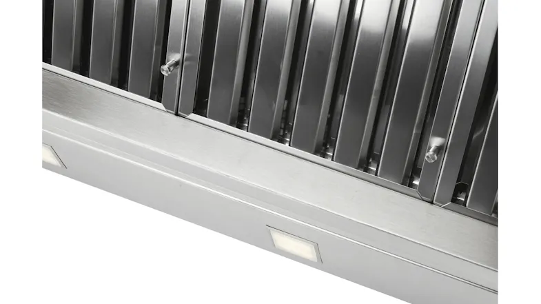 Close-up of a rangehood edge with vertical baffle filters and built-in rectangular light below Close-up of a rangehood edge with vertical baffle filters and built-in rectangular light below