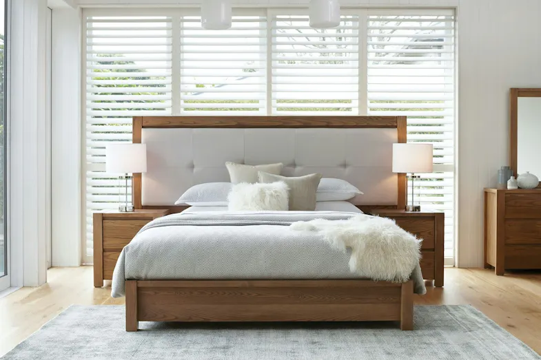 Milford Extended Californian King Bed Frame with wooden bed, white bedding, two lamps, and large windows with blinds Milford Extended Californian King Bed Frame with wooden bed, white bedding, two lamps, and large windows with blinds