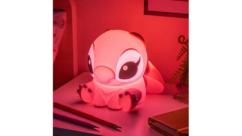 Silicone Angle light illuminated in pink on a desk, casting a warm glow Silicone Angle light illuminated in pink on a desk, casting a warm glow