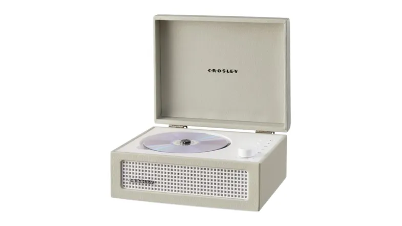 Open beige Crosley CD player with a disc inside, featuring the front speaker grille and a control knob on the right Open beige Crosley CD player with a disc inside, featuring the front speaker grille and a control knob on the right