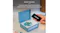 Blue Crosley CD player playing a disc, with a smartphone nearby showing a Bluetooth connection Blue Crosley CD player playing a disc, with a smartphone nearby showing a Bluetooth connection