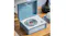 Blue Crosley CD player on a wooden table with a disc inside, control buttons visible, and a stack of CDs beside it Blue Crosley CD player on a wooden table with a disc inside, control buttons visible, and a stack of CDs beside it