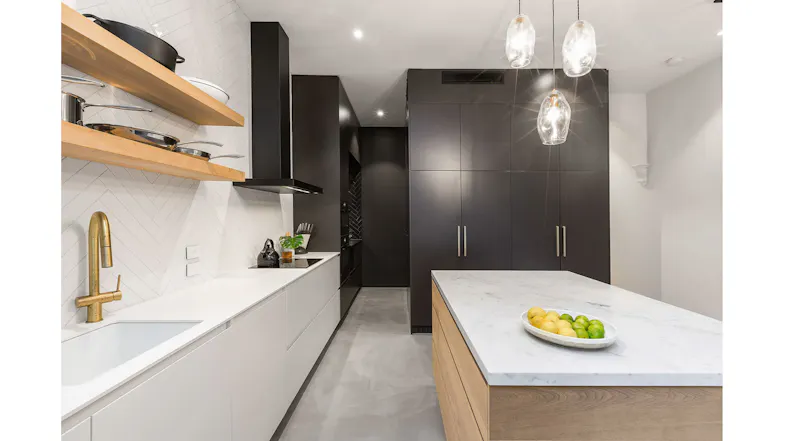 Modern kitchen interior with a black wall-mounted rangehood, white tiled backsplash, wooden shelves and marble island bench Modern kitchen interior with a black wall-mounted rangehood, white tiled backsplash, wooden shelves and marble island bench