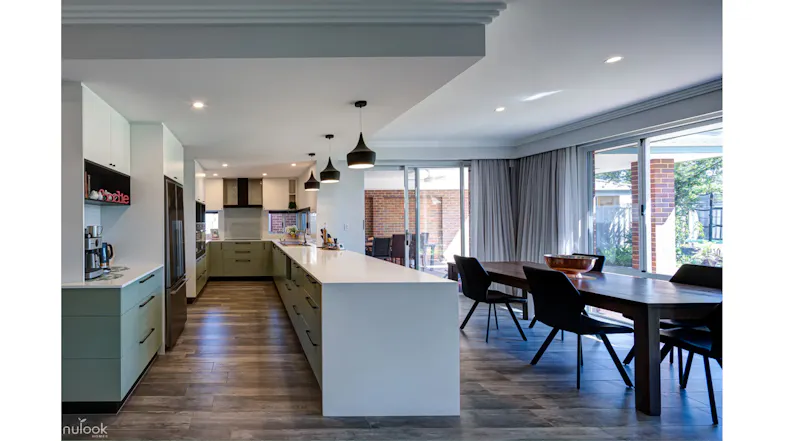 Bright kitchen interior with large island, pendant lighting, and seamless indoor-outdoor living view Bright kitchen interior with large island, pendant lighting, and seamless indoor-outdoor living view