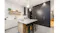 Contemporary kitchen interior with marble countertop island, black cabinetry, gold handles, and pendant lights Contemporary kitchen interior with marble countertop island, black cabinetry, gold handles, and pendant lights