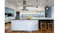 Modern kitchen with stainless steel rangehood above island, white cabinets, pendant lights, and bar stools Modern kitchen with stainless steel rangehood above island, white cabinets, pendant lights, and bar stools