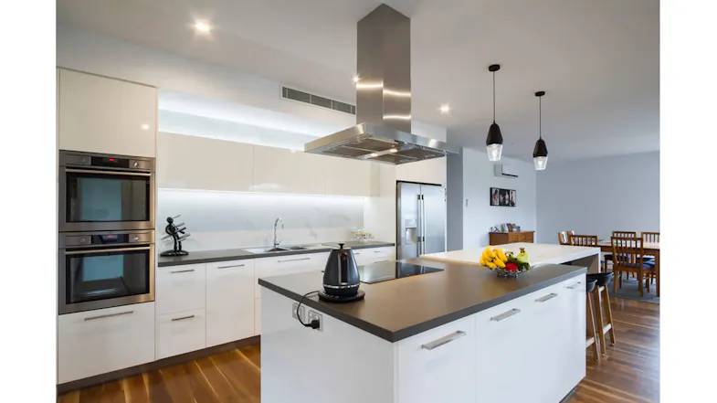 Bright kitchen design with white cabinetry, pendant lighting, and an island seating area Bright kitchen design with white cabinetry, pendant lighting, and an island seating area
