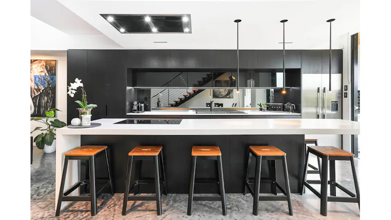 Contemporary kitchen with dark cabinetry and a large island bench, showcasing a ceiling-mounted rangehood Contemporary kitchen with dark cabinetry and a large island bench, showcasing a ceiling-mounted rangehood