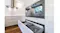 Modern kitchen with stainless steel rangehood, built-in ovens, open drawer storage and white cabinetry layout Modern kitchen with stainless steel rangehood, built-in ovens, open drawer storage and white cabinetry layout
