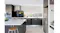 Modern kitchen with a stainless steel rangehood, dark cabinetry, island bench, window splashback and integrated appliances Modern kitchen with a stainless steel rangehood, dark cabinetry, island bench, window splashback and integrated appliances