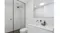 Modern white bathroom with a glass shower, toilet, vanity sink, mirror, and recessed ceiling vent Modern white bathroom with a glass shower, toilet, vanity sink, mirror, and recessed ceiling vent