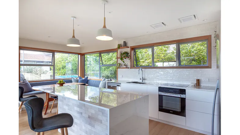 Contemporary kitchen with island bench, white cabinetry and ceiling cassette rangehood modules, filled with natural light Contemporary kitchen with island bench, white cabinetry and ceiling cassette rangehood modules, filled with natural light