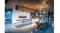 Modern kitchen with a large island, bar stools, a wood slat ceiling, and a ceiling-mounted rangehood above the cooktop Modern kitchen with a large island, bar stools, a wood slat ceiling, and a ceiling-mounted rangehood above the cooktop
