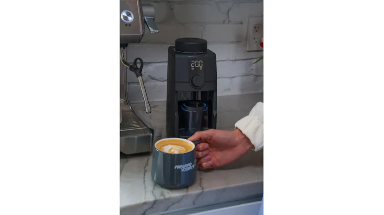 Kitchen countertop scene showcasing a coffee grinder with a latte mug Kitchen countertop scene showcasing a coffee grinder with a latte mug