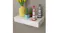 White floating wall shelf holding a yellow vase with tulips, small potted plants, and two striped lighthouse ornaments White floating wall shelf holding a yellow vase with tulips, small potted plants, and two striped lighthouse ornaments