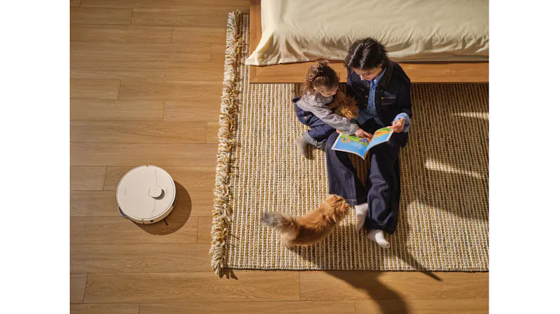 Overhead view showcasing a robot vacuum near a patterned rug Overhead view showcasing a robot vacuum near a patterned rug