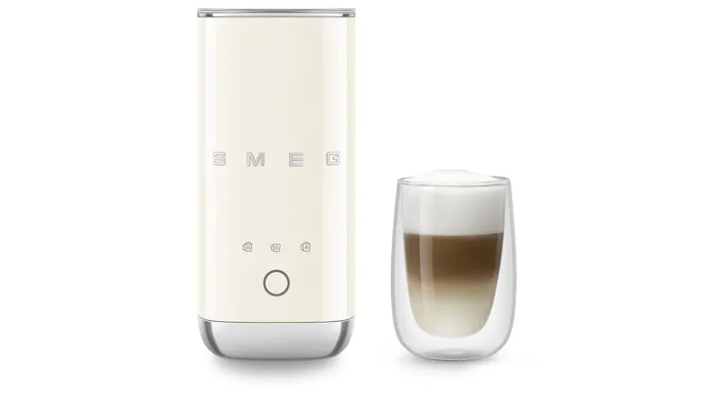 Front view of the cream milk frother next to a glass of a layered coffee drink, demonstrating its use for milk frothing Front view of the cream milk frother next to a glass of a layered coffee drink, demonstrating its use for milk frothing