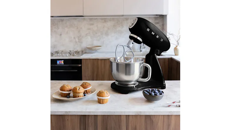 Kitchen countertop scene featuring the Smeg stand mixer with tilt head raised and flat beater attached Kitchen countertop scene featuring the Smeg stand mixer with tilt head raised and flat beater attached