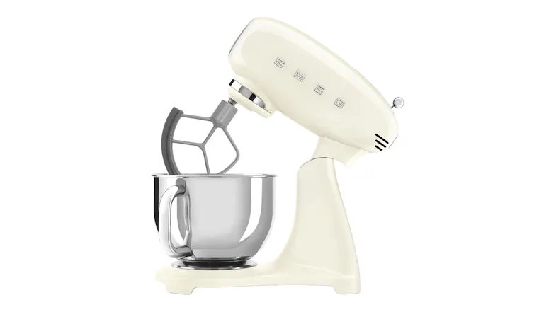 Side view of the glossy cream Smeg stand mixer with tilt head raised and flat beater attachment Side view of the glossy cream Smeg stand mixer with tilt head raised and flat beater attachment