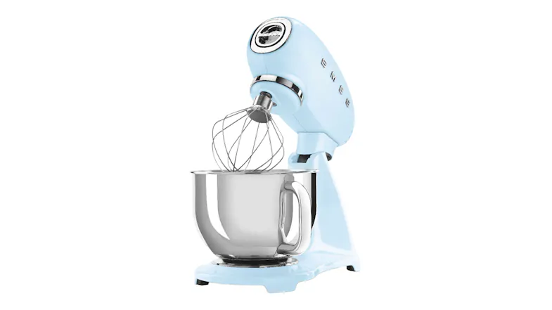 Angled side view of the Smeg stand mixer with tilt head raised and whisk attachment over the stainless steel bowl Angled side view of the Smeg stand mixer with tilt head raised and whisk attachment over the stainless steel bowl