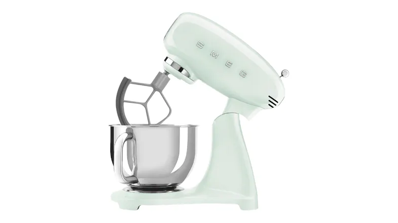 Side view of the glossy pastel green Smeg stand mixer with tilt head raised and flat beater attachment Side view of the glossy pastel green Smeg stand mixer with tilt head raised and flat beater attachment