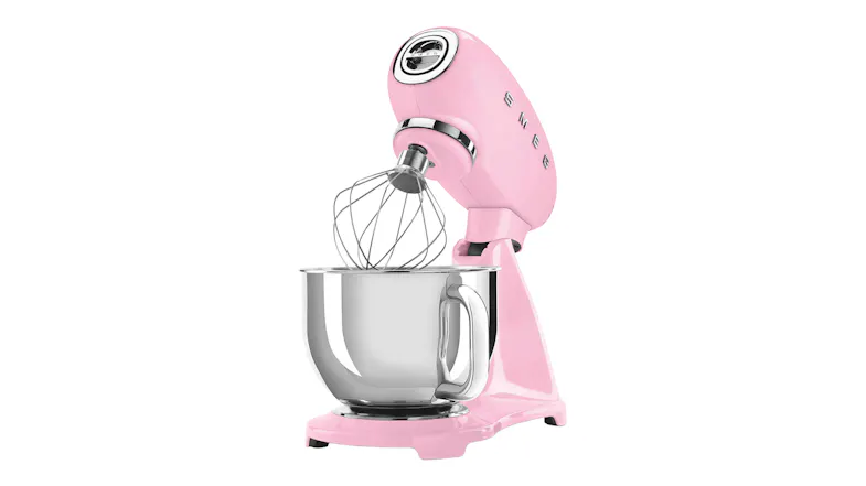 Angled side view of the Smeg stand mixer with tilt head raised and whisk attachment over the stainless steel bowl Angled side view of the Smeg stand mixer with tilt head raised and whisk attachment over the stainless steel bowl