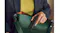 A person is placing the wireless remote in a green leather bag A person is placing the wireless remote in a green leather bag