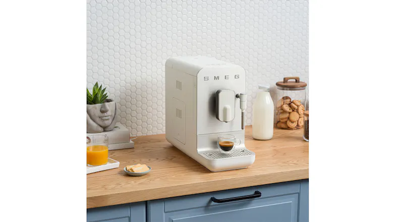 An espresso machine on a wooden countertop next to a glass bottle of milk An espresso machine on a wooden countertop next to a glass bottle of milk
