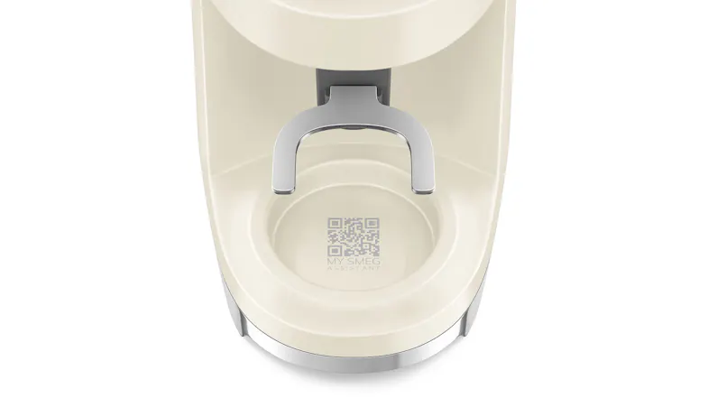 A bottom section of the Smeg coffee grinder showing the QR code labelled “My Smeg Assistant” on the drip tray area A bottom section of the Smeg coffee grinder showing the QR code labelled “My Smeg Assistant” on the drip tray area