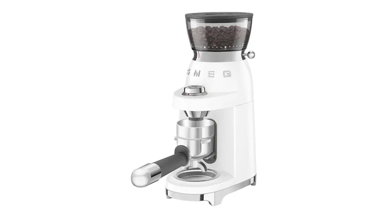 White Smeg coffee grinder with beans in hopper and portafilter attached, showcasing sleek retro-inspired design White Smeg coffee grinder with beans in hopper and portafilter attached, showcasing sleek retro-inspired design