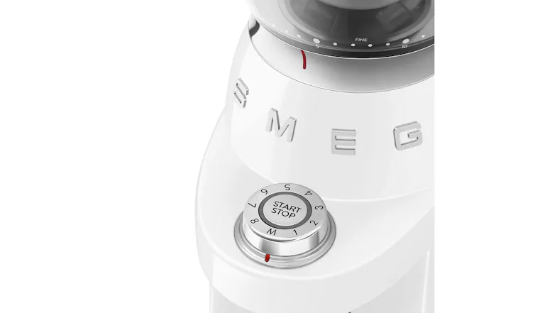 A close-up of a coffee grinder’s start-stop dial and grind adjustment ring marked “fine,” with a red indicator line A close-up of a coffee grinder’s start-stop dial and grind adjustment ring marked “fine,” with a red indicator line