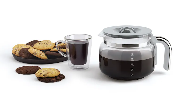A glass carafe next to a coffee cup and a plate of cookies A glass carafe next to a coffee cup and a plate of cookies