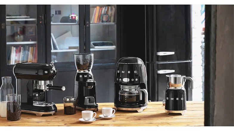 A cosy kitchen counter highlighting a collection of Smeg coffee appliances A cosy kitchen counter highlighting a collection of Smeg coffee appliances