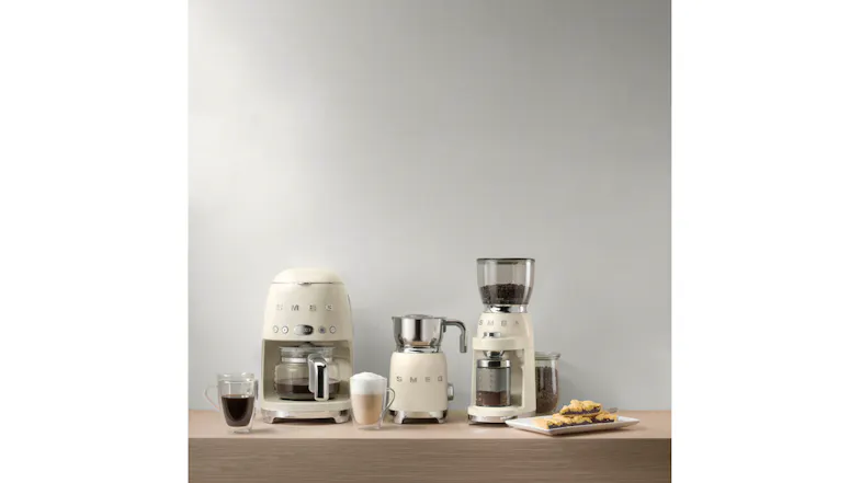 Kitchen counter showing three coffee appliances with cups and pastries Kitchen counter showing three coffee appliances with cups and pastries